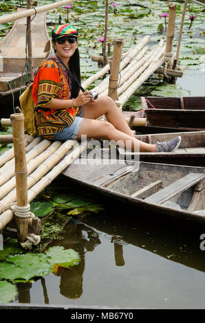 Les voyageurs asiatiques femme thaïlandaise travel visiter et pour prendre le pont de bambou de séance photo avec bateau flottant en bois avec de l'eau lily dans l étang à jardin de la Lo Banque D'Images