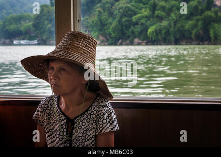 Yangshuo, Chine - le 2 août 2012 : femme chinoise voyageant en bateau dans la rivière Li, près de la ville de Yangshuo, en Chine. Banque D'Images