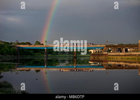 Un Northern Rail class 156 sprinter train passe Carlisle bridge, à Lancaster, sur la rivière lune avec un arc-en-ciel se reflétant dans la rivière Banque D'Images