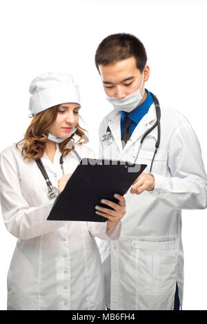 Le personnel médical ayant multiethnique discussion dans un couloir de l'hôpital. Homme et femme nurse wearing blue scrubs travaillant dans une clinique médicale. L'hôpital deux Banque D'Images