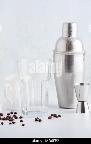 Verres vides et un pot à lait avec des grains de café et shaker sur la table. Banque D'Images