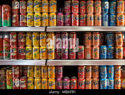 L'armoire frigorifique avec des canettes de boissons gazeuses, boissons soda, boissons, rafraîchissements, froid, doux, liquide, bonbons & confiserie produits sucrés maintenant soumis à l'impôt sur le sucre pour contrôler l'obésité dans une armoire de réfrigération. UK Banque D'Images