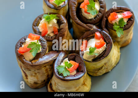 Rouleaux d'aubergine farcis de fromage décoré par paprika rouge et le persil. Banque D'Images