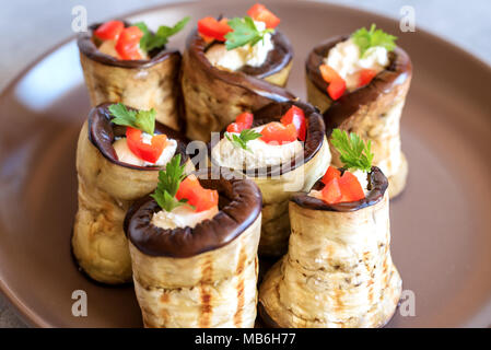 Rouleaux d'aubergine farcis de fromage décoré par paprika rouge et le persil. Banque D'Images