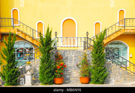 Pots de fleurs sur les escaliers sur mur de pierre grise avec mur jaune.porte et escaliers sur mur jaune dans la région de Old alley Banque D'Images