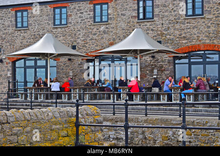 Les gens enjoyi de vous détendre en prenant un verre à l'extérieur du port Bar & cuisine dans la rénovation de bâtiments par le port de Porthcawl, S.Wales Banque D'Images