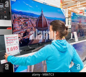 Femme à la recherche de nouveaux Samsung 4k haute définition télé des courbes store électrique Banque D'Images