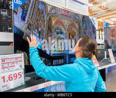 Femme à la recherche de nouveaux Samsung 4k haute définition télé des courbes store électrique Banque D'Images