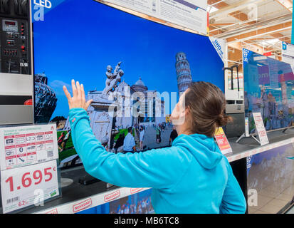 Femme à la recherche de nouveaux Samsung 4k haute définition télé des courbes store électrique Banque D'Images