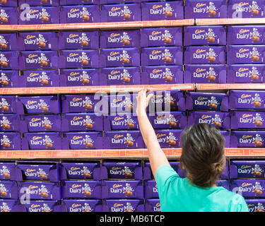 Femme sélection barre de chocolat au lait Cadbury supermarché à afficher. Banque D'Images