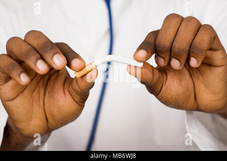 Close-up d'un jeune médecin se casse une cigarette et donne des conseils pour arrêter de fumer. Concept de soins de santé Banque D'Images