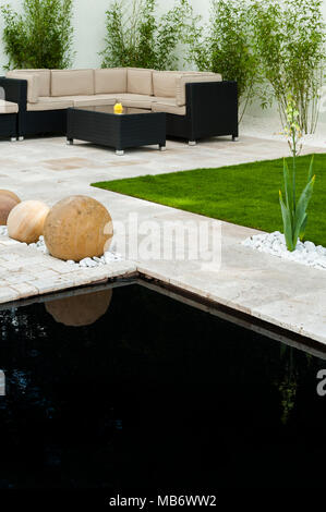 Contemporain et minimaliste, 'Breathe' show élégant jardin avec patio, coin salon, étang et sphères de pierre - RHS Flower Show, Tatton Park, Angleterre, Royaume-Uni. Banque D'Images