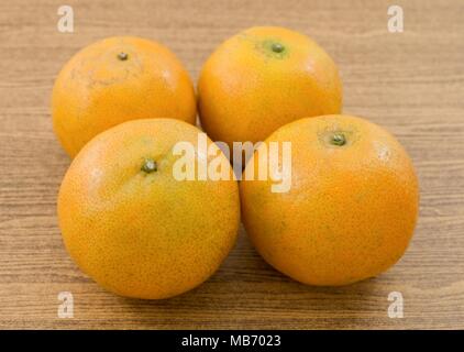 4 Oranges Douces et mûres sur une table en bois, l'Orange est le fruit de l'espèces d'agrumes. Banque D'Images