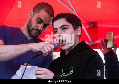 Londres, Royaume-Uni. 7 avril, 2018. Le rappeur Lowkey joint deux enfants à lire les noms de Palestiniens tués par des snipers israéliens lors de la grande marche du retour à Gaza à la fin d'un rassemblement a réuni des centaines de personnes à l'extérieur de Downing Street. Credit : Mark Kerrison/Alamy Live News Banque D'Images