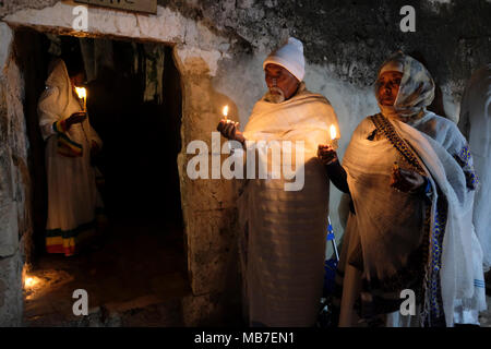 Les chrétiens orthodoxes éthiopiens tiennent des bougies pendant la cérémonie du feu Saint au monastère de Deir El-Sultan situé sur le toit de l'église du Saint-Sépulcre dans la vieille ville est de Jérusalem Israël. Les chrétiens éthiopiens commémorent les événements autour de la crucifixion de Jésus-Christ, menant à sa résurrection à Pâques qui, dans la langue amharique, est appelée Fasika, originaire du mot grec Pascha. Banque D'Images