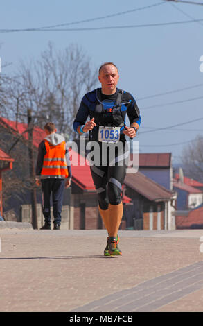 Checiny, Pologne, 7 avril 2018. Runner sur une rue. CROSSRUN amateur, l'exécution de la concurrence. Ce concours est divisé en deux catégories : 10 km et 21,5 km. Crédit : Pawel Burgiel/Alamy Live News. Banque D'Images
