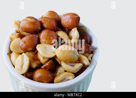 Close up de cacahuètes salées dans un bol blanc avec fond blanc Banque D'Images