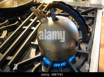 Richard Sapper Alessi bouilloire avec sifflet mélodique de l'eau bouillante sur une cuisinière à gaz haut Banque D'Images
