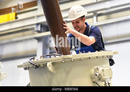 Exploitant de l'installation d'un transformateur dans une usine industrielle en génie mécanique Banque D'Images