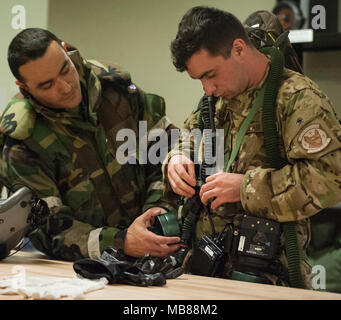 Un U.S. Air Force 353e Escadron de soutien des opérations spéciales technicien d'équipement d'équipage aide un 17e Escadron d'opérations spéciales l'arrimeur mis sur l'œil de l'équipage et du système de protection respiratoire (AERPS) Le 31 janvier 2018, à Kadena Air Base, au Japon. La 17e SOS exécuté de la formation en vol avec l'équipement AERPS comme une partie de la capacité à survivre et à l'exploitation (ATSO) de la formation. (U.S. Air Force Banque D'Images