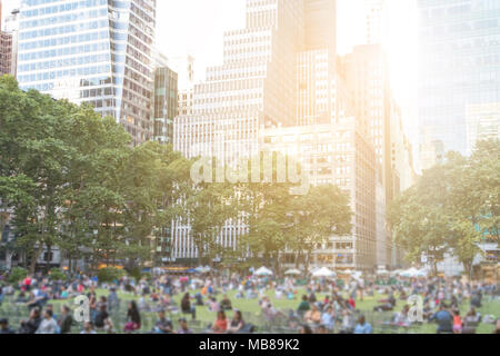 Les gens de Bryant Park à Manhattan, New York City, avec les bâtiments de la Midtown skyline en arrière-plan Banque D'Images