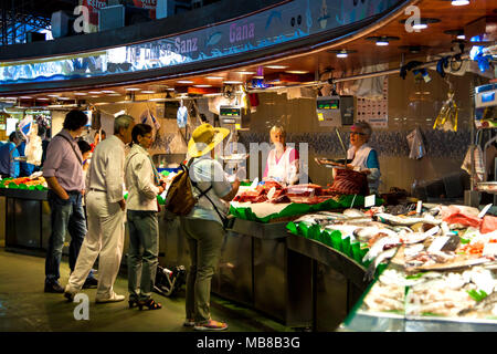 Les gens à l'achat de viande et de fruits de mer frais cale au marché de la Boqueria à Barcelone, Espagne Banque D'Images