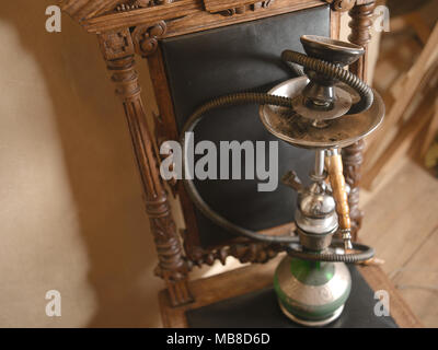 Tuyau narguilé placé sur une chaise en bois vintage, high angle shot verticale Banque D'Images
