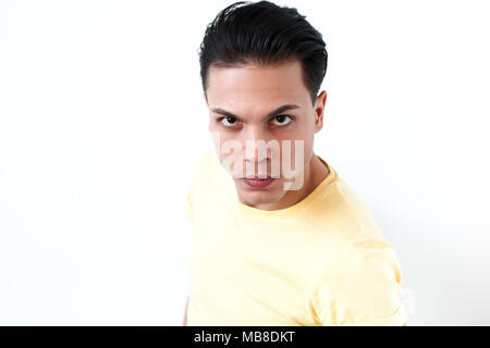 Portrait de l'expression de colère man looking at camera avec rage. Émotions et sentiments concept. Tourné à l'intérieur, fond gris Banque D'Images