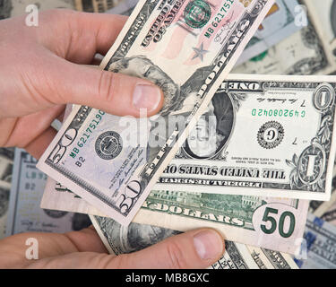 La main de l'homme comptant us dollar bills permanente pour toutes les dettes publiques et privées, Banque D'Images