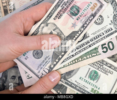 La main de l'homme comptant us dollar bills permanente pour toutes les dettes publiques et privées, Banque D'Images
