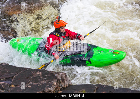 Groupe d'adolescents de la formation dans des kayaks à Etive River Falls, Glencoe, Highlands, Scotland, UK en mars - kayakiste unique Banque D'Images