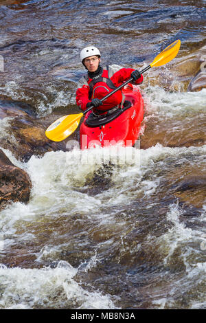 Groupe d'adolescents de la formation dans des kayaks à Etive River Falls, Glencoe, Highlands, Scotland, UK en mars - kayakiste unique Banque D'Images