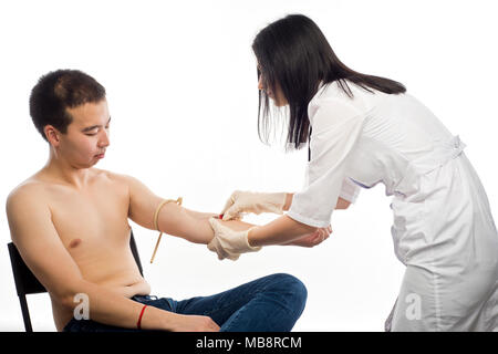 Une femme médecin les injections dans une veine ou prend un test sanguin à partir de la veine de la main du patient de l'apparence de l'Asie de l'Est. Banque D'Images