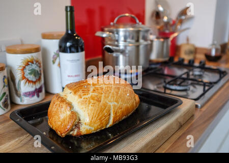 Maison traditionnelle en Beef Wellington avec filet de boeuf en croûte servi avec pommes de terre au gratin et Cavola Nero terre sauce vin rouge Banque D'Images