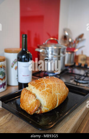 Maison traditionnelle en Beef Wellington avec filet de boeuf en croûte servi avec pommes de terre au gratin et Cavola Nero terre sauce vin rouge Banque D'Images