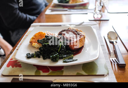 Maison traditionnelle en Beef Wellington avec filet de boeuf en croûte servi avec pommes de terre au gratin et Cavola Nero terre sauce vin rouge pour dimanche lunc Banque D'Images