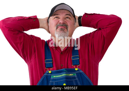 Agriculteur ou travailleur en bleu de travail à la recherche avec les mains jointes derrière la tête et une expression dédaigneuse des grimaces comme il se pense over white Banque D'Images
