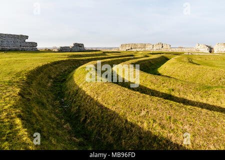L'Angleterre, Richborough château romain. La mi-3e siècle fossés avec mur nord de la poterne et Saxon Shore fort en arrière-plan. Banque D'Images