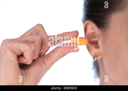 Young Girl holding des bouchons d'Oreille, près de l'oreille Banque D'Images