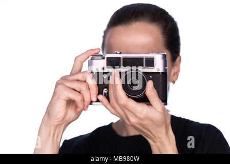 Girl in black prend des photos sur vintage camera sur fond blanc Banque D'Images