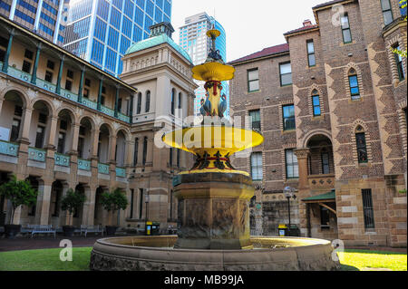 La brique apparente du Royal Eye Hospital, Sydney, Australie entourent ornate fountain contre l'arrière-plan d'imposants gratte-ciel modernes de bureau, Banque D'Images