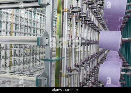 Fil textile sur l'ourdissage machine. machines et matériel dans une usine de textile Banque D'Images