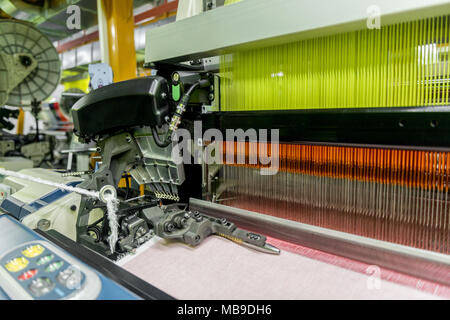 À tisser dans une usine de textile, gros plan de la ligne de production de tissus industriels. Banque D'Images