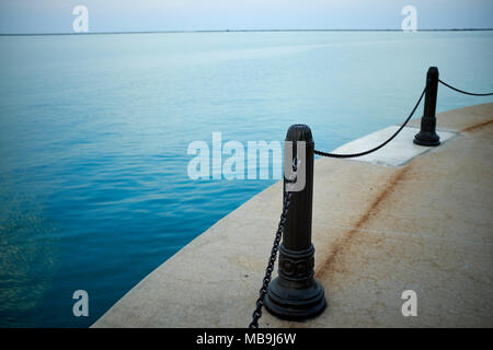 Bornes de métal avec des chaînes de sécurité sur le Navy Pier, Chicago, Illinois sur une section courbe de la promenade au-dessus d'un océan calme Banque D'Images