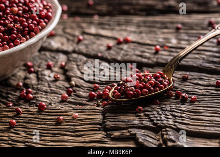 Poivre rouge dans un bol et la cuillère sur table en chêne. Banque D'Images