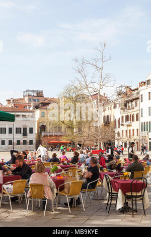 Campo San Polo, San Polo, Venise, Vénétie, Italie au printemps avec les touristes assis bénéficiant d'un repas et des boissons au Bar Pizzeria Cico dans le foregrou Banque D'Images