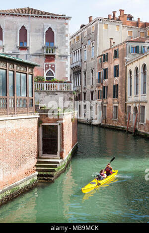 Couple de touristes kayak sur le Rio San Polo, San Polo, Venise, Vénétie Italie dans un kayak de location qu'ils profiter de visites l'arrière de la ville de canaux Banque D'Images