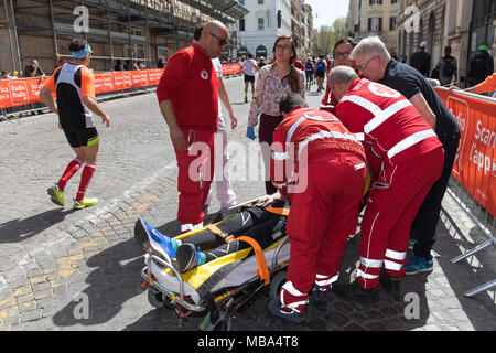 Rome, Italie - 8 Avril 2018 : un athlète participe à la 24e édition du Marathon de Rome et courir pour le plaisir est secouru et transporté sur un brancard par le personnel médical, en raison d'une maladie en raison de la grande fatigue et de la chaleur. Credit : Polifoto/Alamy Live News Banque D'Images