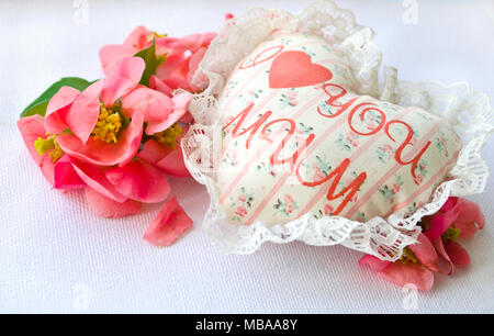 Coeur blanc fait main textiles avec l'inscription J'aime maman et pétales de roses rouges sur fond blanc. Une bonne fête des mères thème. Banque D'Images