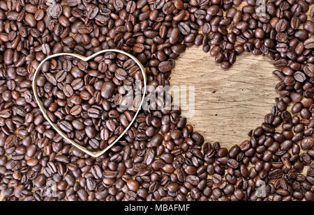 En forme de cœur, deux dans les fèves de café sur fond de bois Banque D'Images